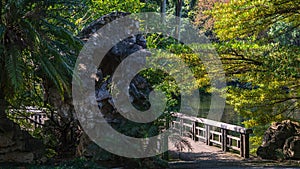 Beautiful natural scenery with a rock formation and a bridge over a lake captured in Nanning