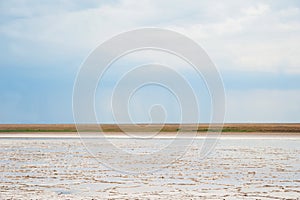 Beautiful natural textural background on a salt lake, river. Salt lake Elton, Russia, before rain and thunder, sunset on the water