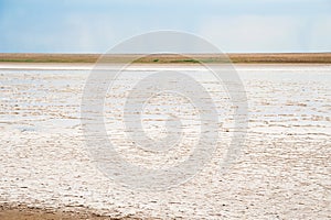 Beautiful natural textural background on a salt lake, river. Salt lake Elton, Russia, before rain and thunder, sunset on the water