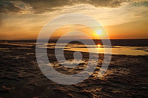 Beautiful natural textural background of the sunset on the lake, river. Salt lake Elton, sunset on the water