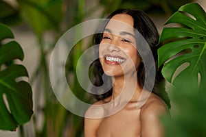 Beautiful natural woman with monstera leaves