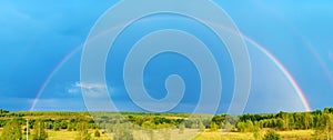 Beautiful nature landscape with double full rainbow above field panorama