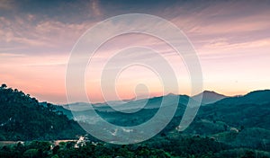 Beautiful nature landscape of mountain range with sunset sky and clouds. Rural village in mountain valley in Thailand. Scenery