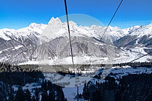 Beautiful nature lanscape with Caucasus mountain and pine forest covered with snow in winter. Cable car at Hatsvali ski resort