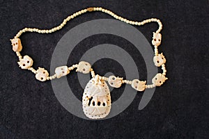 Necklace of white ivory on the black felt photo