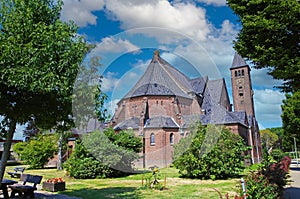 Beautiful neo gothic medieval St. Rochus church, green garden trees,  now in use as Limburg archery museum - Steyl, Netherlands