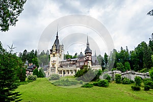 Beautiful neo-Renaissance building of Peles Castle Castelul Peles near Bucegi Mountains Muntii Bucegi in a cloudy summer day