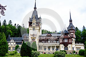 Beautiful neo-Renaissance building of Peles Castle Castelul Peles near Bucegi Mountains Muntii Bucegi in a cloudy summer day