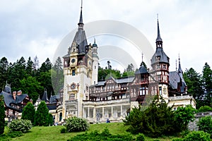 Beautiful neo-Renaissance building of Peles Castle Castelul Peles near Bucegi Mountains Muntii Bucegi in a cloudy summer day