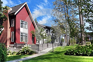 Beautiful new contempory suburban attached townhomes with colorful summer gardens in a Canadian neighborhood.