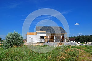 Beautiful New Cozy House Building Construction Exterior. Cozy house with Dormers, Skylights, Ventilation, Gutter, Drainage, Plaste