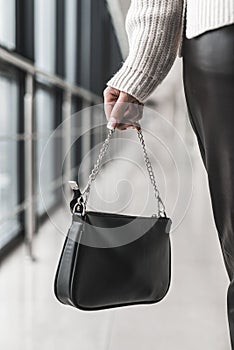 beautiful new stylish black bag in a stylish lady in her hands.