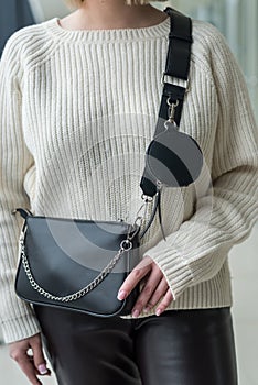 beautiful new stylish black bag in a stylish lady in her hands.