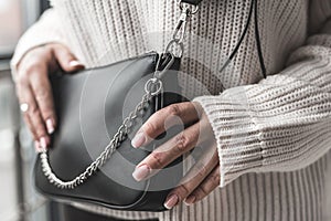 beautiful new stylish black bag in a stylish lady in her hands.