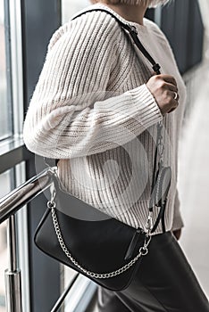beautiful new stylish black bag in a stylish lady in her hands.