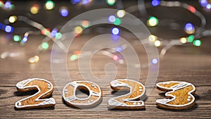 Beautiful New Year card for happy 2023 from ornate gingerbread numerals and LED light strings