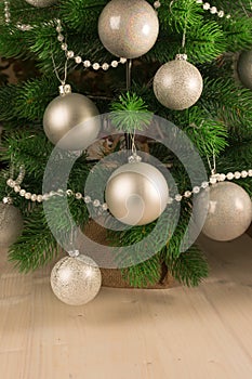 Beautiful New Year`s light background. Part of the Christmas tree decorated with silver balls and white beads. Festive