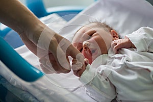 Beautiful newborn baby boy, laying in crib in prenatal hospital