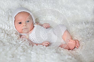 Beautiful newborn baby boy, looking curiously at camera