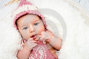 Beautiful newborn baby girl lying in the basket and looking towards camera photo