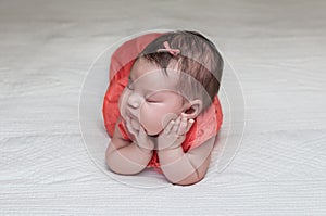 Beautiful newborn baby sleeping on her elbows and hands