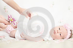 Beautiful newborn girl holding a flower