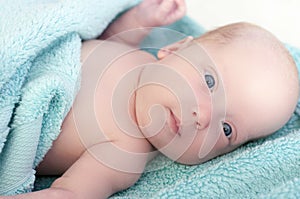 A beautiful newborn girl lies wrapped in a towel after bathing. Toning, blur photo