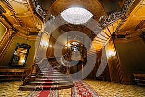 Beautiful newlywed bride and groom posing on old stairs with the background of breathtaking royal wooden vintage mansion