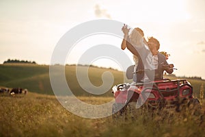 Beautiful newlyweds driving quad together Rural wedding concept