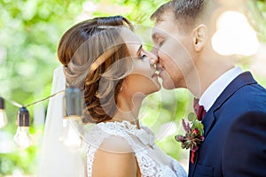Beautiful newlyweds sensually kissing in park