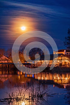 Beautiful night scene on the lake with a bright moon on the sky