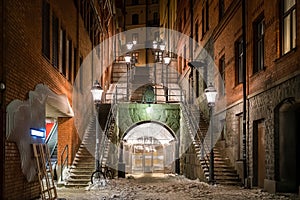 Beautiful night scene of stone steps  with bright lamp posts and vintage old red brick building over pedestrian underground tunnel