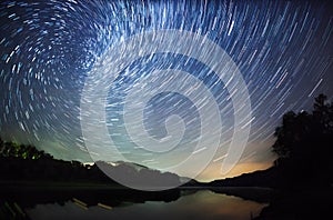 Beautiful night sky, the Milky Way, star trails and the trees