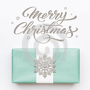 Beautiful nordic christmas gift with silver snowflake isolated on white background. Turquoise colored wrapped xmas box.