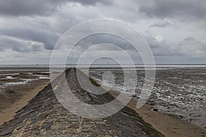 Beautiful North Sea coast of Cuxhaven in Germany. Overcast sky with clouds over the sea at low tide