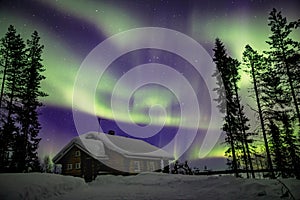 Beautiful Northern Lights Aurora Borealis in the night sky over winter Lapland landscape, Finland, Scandinavia