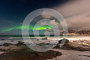 Beautiful Northern Lights in Lofoten Island in Norway. Aurora Boreal over the beach. Majestic green night sky.  Nightscape full of
