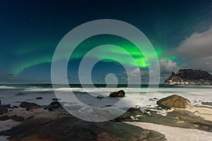 Beautiful Northern Lights in Lofoten Island in Norway. Aurora Boreal over the beach. Majestic green night sky. Nightscape full os