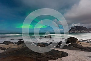 Beautiful Northern Lights in Lofoten Island in Norway. Aurora Boreal over the beach. Majestic green night sky.  Nightscape full os