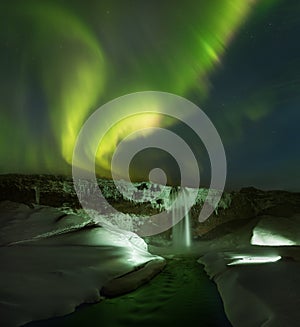 Beautiful Northern lights over Seljalandsfoss waterfall, Iceland. Winter time on most popular place.