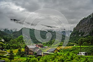 Beautiful Norway forest landscape with small village in the valley surrounded by green hills and mountain