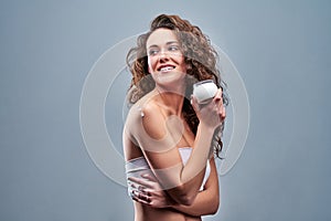 Beautiful nourished woman holding cream for her skin