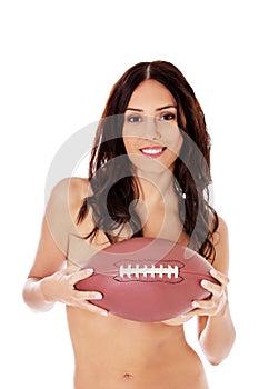 Beautiful nude woman holding american football ball.