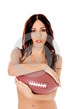 Beautiful nude woman holding american football ball.