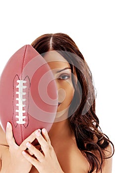Beautiful nude woman holding american football ball.