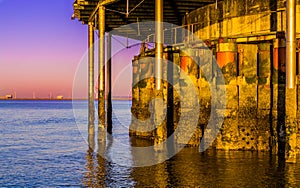 Beautiful ocean scenery from under the jetty of Blankenberge beach, Belgium, Sunset with a colorful sky