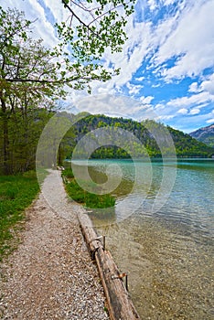 Beautiful Offensee lake landscape with hiking trails, forest, clouds and reflections in the water in Austrian Alps