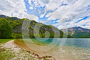 Beautiful Offensee lake landscape with hiking trails, forest, clouds and reflections in the water in Austrian Alps