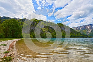 Beautiful Offensee lake landscape with hiking trails, forest, clouds and reflections in the water in Austrian Alps