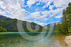 Beautiful Offensee lake landscape with mountains, forest, clouds and reflections in the water in Austrian Alps